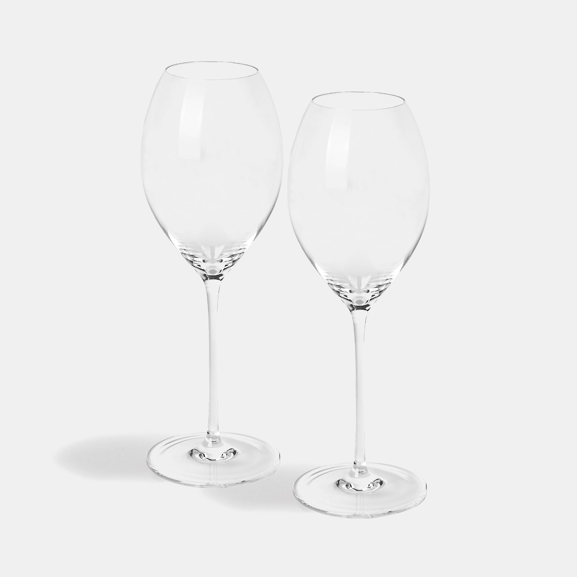 A pair of champagne glasses with tapered bowls rather than narrow flutes.